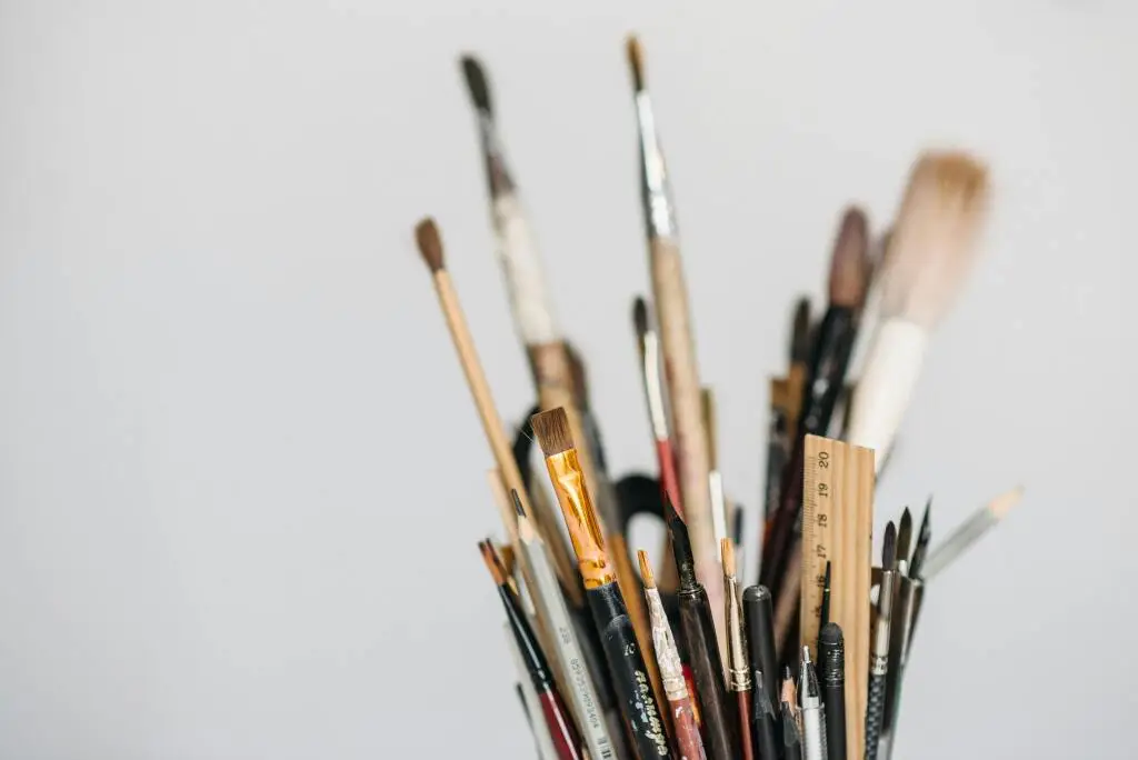 Photo d'un pot avec des pinceaux et crayons d'illustrateur
